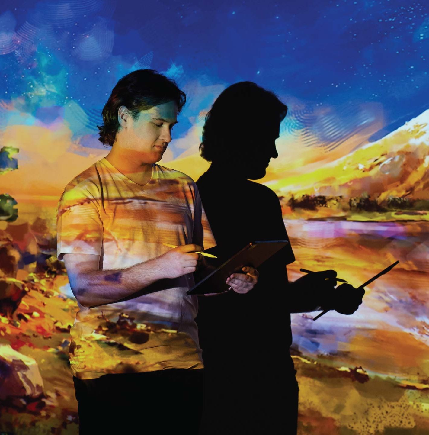 Tom Trengrove working on tablet with digital landscape painting projected onto him